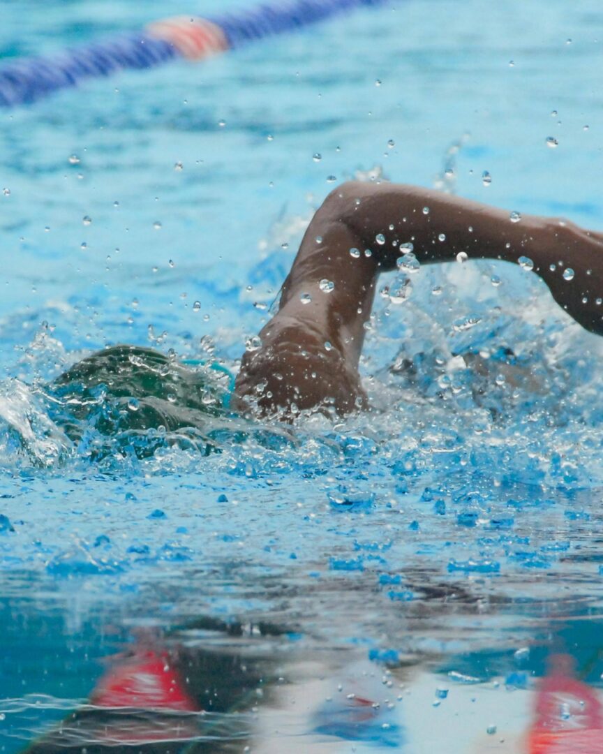 A person swimming in the water with their arms stretched out.